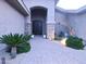 Grand front entrance with a paved walkway, meticulous landscaping, and elegant stone pillars highlighting the double doors at 136 E Desert Wind Dr, Phoenix, AZ 85048