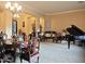Bright living room with a piano and ornate wooden furniture under a decorative chandelier at 136 E Desert Wind Dr, Phoenix, AZ 85048