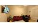Well-lit home office with red couch, modern desk, and TV on the wall at 136 E Desert Wind Dr, Phoenix, AZ 85048