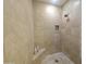 Walk-in shower featuring neutral colored tile surround, shampoo niche, corner seat, and modern shower head at 136 E Desert Wind Dr, Phoenix, AZ 85048