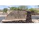 Close-up of the Whistling Rock community sign featuring stacked stone and desert landscaping at 136 E Desert Wind Dr, Phoenix, AZ 85048