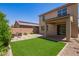 Large backyard showcasing green artificial turf, a covered patio, and plenty of space for outdoor activities at 14180 W Willow Ave, Surprise, AZ 85379