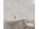 Bright powder room with a pedestal sink, a large mirror, and a white toilet at 14180 W Willow Ave, Surprise, AZ 85379