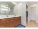 Spacious bathroom with double sinks, wood cabinets, and a walk-in closet at 14180 W Willow Ave, Surprise, AZ 85379