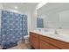 Bathroom with double vanity, tile floors, and a blue shower curtain at 14180 W Willow Ave, Surprise, AZ 85379
