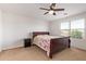 Bright bedroom with a floral comforter, a ceiling fan, and a window at 14180 W Willow Ave, Surprise, AZ 85379