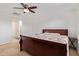 Bedroom with a dark wooden bed frame, neutral carpet, and a ceiling fan at 14180 W Willow Ave, Surprise, AZ 85379