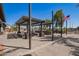 Community pergola featuring string lights, picnic tables, and rock-filled planters, and an American flag at 14180 W Willow Ave, Surprise, AZ 85379