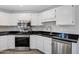 Updated kitchen featuring stainless steel appliances, white cabinets, and dark countertops at 15050 N Thompson Peak Pkwy # 1001, Scottsdale, AZ 85260