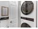 Bright laundry area with modern LG stackable washer and dryer, vanity, sink and mirror at 15050 N Thompson Peak Pkwy # 1001, Scottsdale, AZ 85260