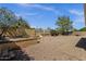 Manicured backyard featuring tiered landscape, rock ground cover, mature trees and ample space at 16002 E Gleneagle Dr, Fountain Hills, AZ 85268