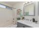 Bright bathroom featuring a shower-tub combo, modern vanity with quartz countertop, and decorative accents at 17220 N 55Th Ave, Glendale, AZ 85308