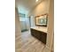 Modern bathroom with a gray vanity, a white countertop, decorative mirrors, and a walk-in shower at 17324 W Royal Palm Rd, Waddell, AZ 85355