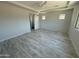 Light and airy bedroom features light wood-look tile floors, barn door to ensuite, and tray ceiling at 17324 W Royal Palm Rd, Waddell, AZ 85355