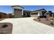 Spacious home featuring a two-car and single-car garage, a driveway, and neutral exterior color schemes with stone accents at 17324 W Royal Palm Rd, Waddell, AZ 85355
