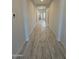 Long hallway with light wood-look tile flooring, recessed lighting, and neutral colored walls at 17324 W Royal Palm Rd, Waddell, AZ 85355