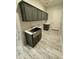 A laundry room with gray cabinets, a countertop, a stainless steel farmhouse sink, and white doors at 17324 W Royal Palm Rd, Waddell, AZ 85355