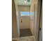 Modern shower stall with gray tile floor, subway tile surround, and horizontal window allowing natural light at 17324 W Royal Palm Rd, Waddell, AZ 85355