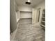 Spacious walk-in closet with wood-look tile flooring, shelving and rod system offering ample storage at 17324 W Royal Palm Rd, Waddell, AZ 85355