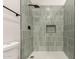 Updated shower with modern grey tiling, a built-in niche, and black hardware for a sleek, contemporary look at 1736 N Ashbrook Cir, Mesa, AZ 85213