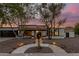 Charming home exterior with desert landscaping, walkway lighting, and attractive architectural features under a twilight sky at 1736 N Ashbrook Cir, Mesa, AZ 85213