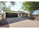Welcoming single-story home featuring a dark garage door, charming entrance, desert landscape, and a sunny curb appeal at 1736 N Ashbrook Cir, Mesa, AZ 85213