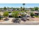 Charming home with a well-manicured front yard, mature trees, and a welcoming entrance at 1736 N Ashbrook Cir, Mesa, AZ 85213