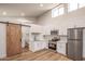 Modern kitchen with white cabinets, stainless steel appliances, and an adjacent barn door leading to the bathroom at 1736 N Ashbrook Cir, Mesa, AZ 85213