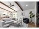 Bright living room with beamed ceiling, neutral palette, stylish furniture, and a view to the backyard pool at 1736 N Ashbrook Cir, Mesa, AZ 85213