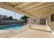 The covered patio offers a shady spot to relax by the refreshing swimming pool at 1736 N Ashbrook Cir, Mesa, AZ 85213