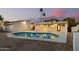 The backyard oasis features a sparkling pool, covered patio, and desert landscape for relaxation and privacy at 1736 N Ashbrook Cir, Mesa, AZ 85213