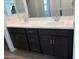 Bathroom vanity with a double sink, dark cabinets, and hard surface flooring at 17989 W Lupine Ave, Goodyear, AZ 85338