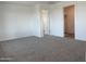 Bedroom featuring neutral carpet and an open closet with a smooth door at 17989 W Lupine Ave, Goodyear, AZ 85338