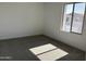 Empty bedroom features neutral carpet, base trim and natural lighting at 17989 W Lupine Ave, Goodyear, AZ 85338