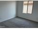 Empty bedroom features neutral carpet, base trim and natural lighting at 17989 W Lupine Ave, Goodyear, AZ 85338