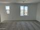 Bright bedroom with neutral carpet and two large windows at 17989 W Lupine Ave, Goodyear, AZ 85338