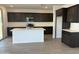 Spacious kitchen featuring a center island, modern appliances, and dark cabinetry at 17989 W Lupine Ave, Goodyear, AZ 85338