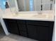 Modern bathroom featuring a double sink vanity with a white countertop and sleek, black cabinetry at 18061 W Lupine Ave, Goodyear, AZ 85338