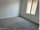 A bright bedroom with gray carpeting and one window at 18061 W Lupine Ave, Goodyear, AZ 85338