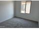 A bright bedroom with gray carpeting and one window at 18061 W Lupine Ave, Goodyear, AZ 85338