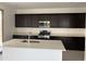 Modern kitchen with dark cabinets, stainless steel appliances, and center island at 18061 W Lupine Ave, Goodyear, AZ 85338