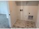 A modern laundry room featuring gray patterned flooring at 18061 W Lupine Ave, Goodyear, AZ 85338