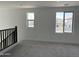 Carpeted loft space with natural light from two windows at 18061 W Lupine Ave, Goodyear, AZ 85338