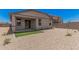 Low maintenance backyard featuring gravel, small patch of turf, and a covered patio at 18374 W Poston Dr, Surprise, AZ 85387