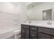 Bathroom features a double vanity with dark cabinets, a bathtub, and a toilet at 18374 W Poston Dr, Surprise, AZ 85387