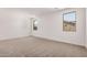 Minimalist bedroom with two windows, neutral carpeting, and bright white walls, providing a serene atmosphere at 18374 W Poston Dr, Surprise, AZ 85387