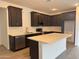 Modern kitchen featuring dark cabinets, stainless steel appliances, and a large island at 18374 W Poston Dr, Surprise, AZ 85387