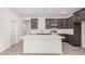 Bright kitchen with modern appliances, white subway tile backsplash, and an eat-in island at 18374 W Poston Dr, Surprise, AZ 85387