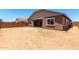 Rear exterior view of home with a large dirt backyard and covered patio at 21845 E Bonanza Ct, Queen Creek, AZ 85142
