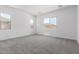 Bright bedroom with three windows and neutral carpeting at 21845 E Bonanza Ct, Queen Creek, AZ 85142